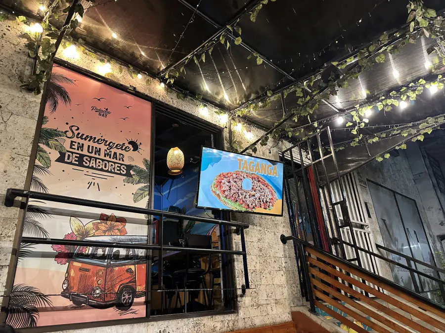 Terraza de Patacón Bay en la Av. 33, con luces colgantes y mural